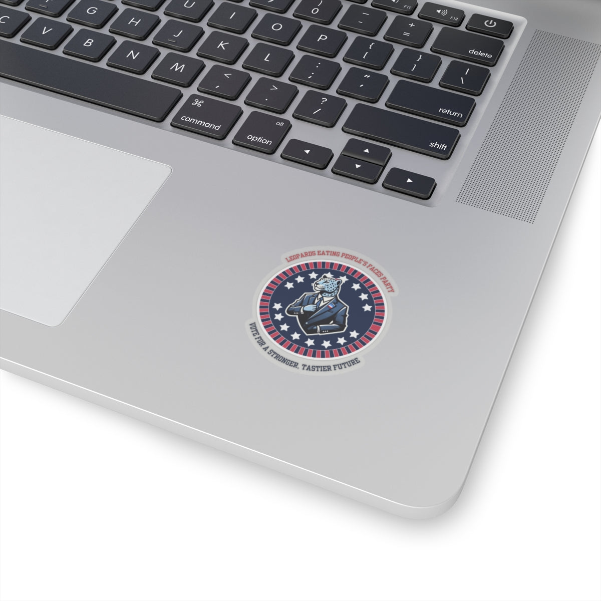Funny political leopard face eating party sticker on silver laptop keyboard area by Printify