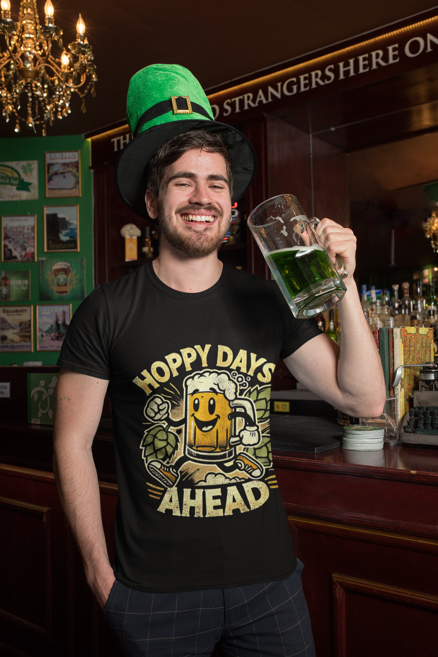 Man in pub wearing Printify black funny beer lover hoppy days ahead t-shirt holding green beer mug and leprechaun hat