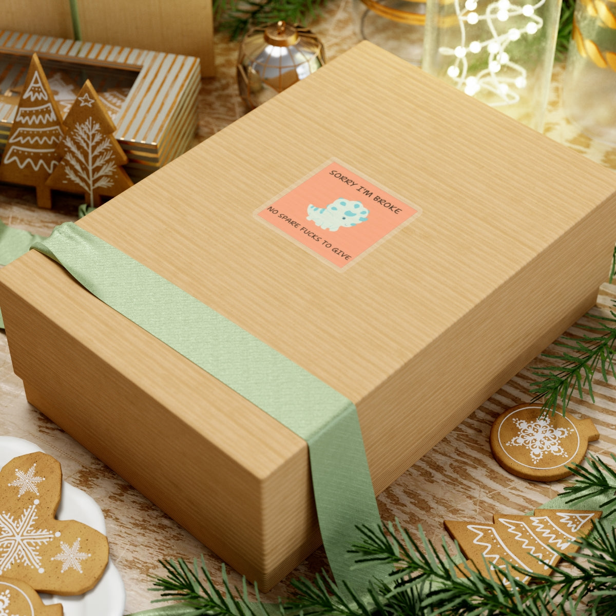 Gift box with no fucks to give funny dino sticker on top surrounded by holiday-themed decorations