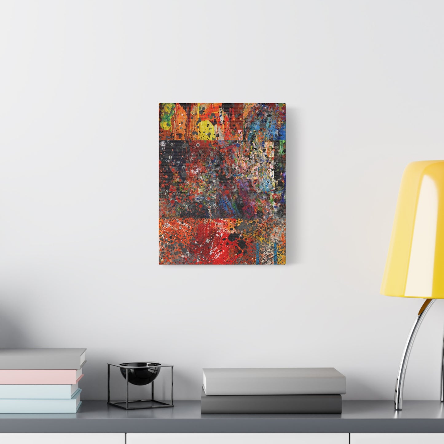 Red and orange abstract art canvas print hanging on wall over modern console with books