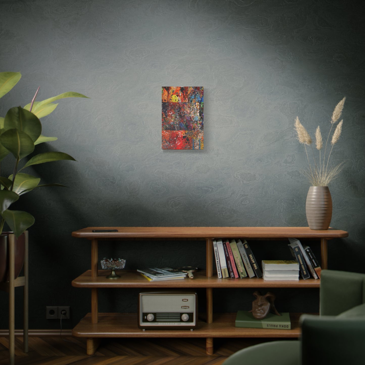 Red and orange abstract art canvas print hanging on wall above wooden shelf with books and vintage radio