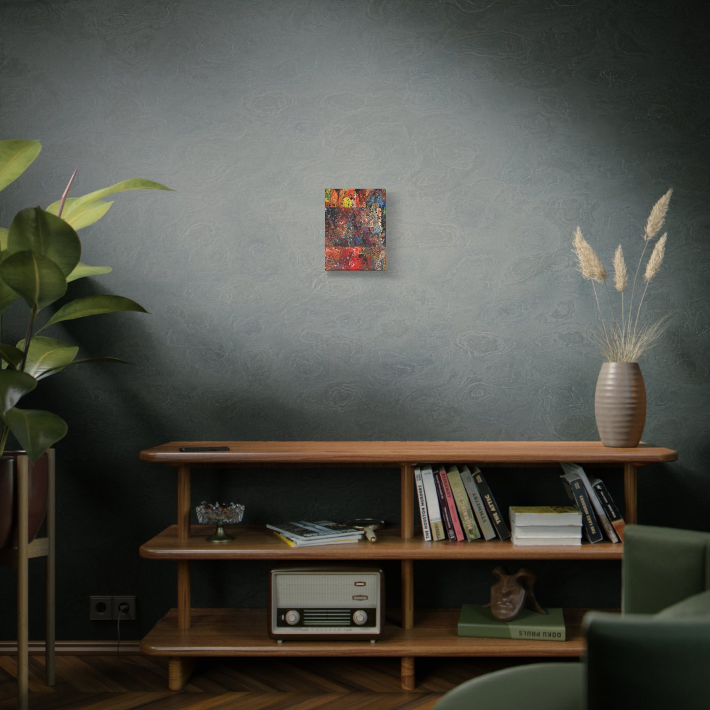 Red and orange abstract art canvas print hanging on gray wall above wooden shelf with books and decor