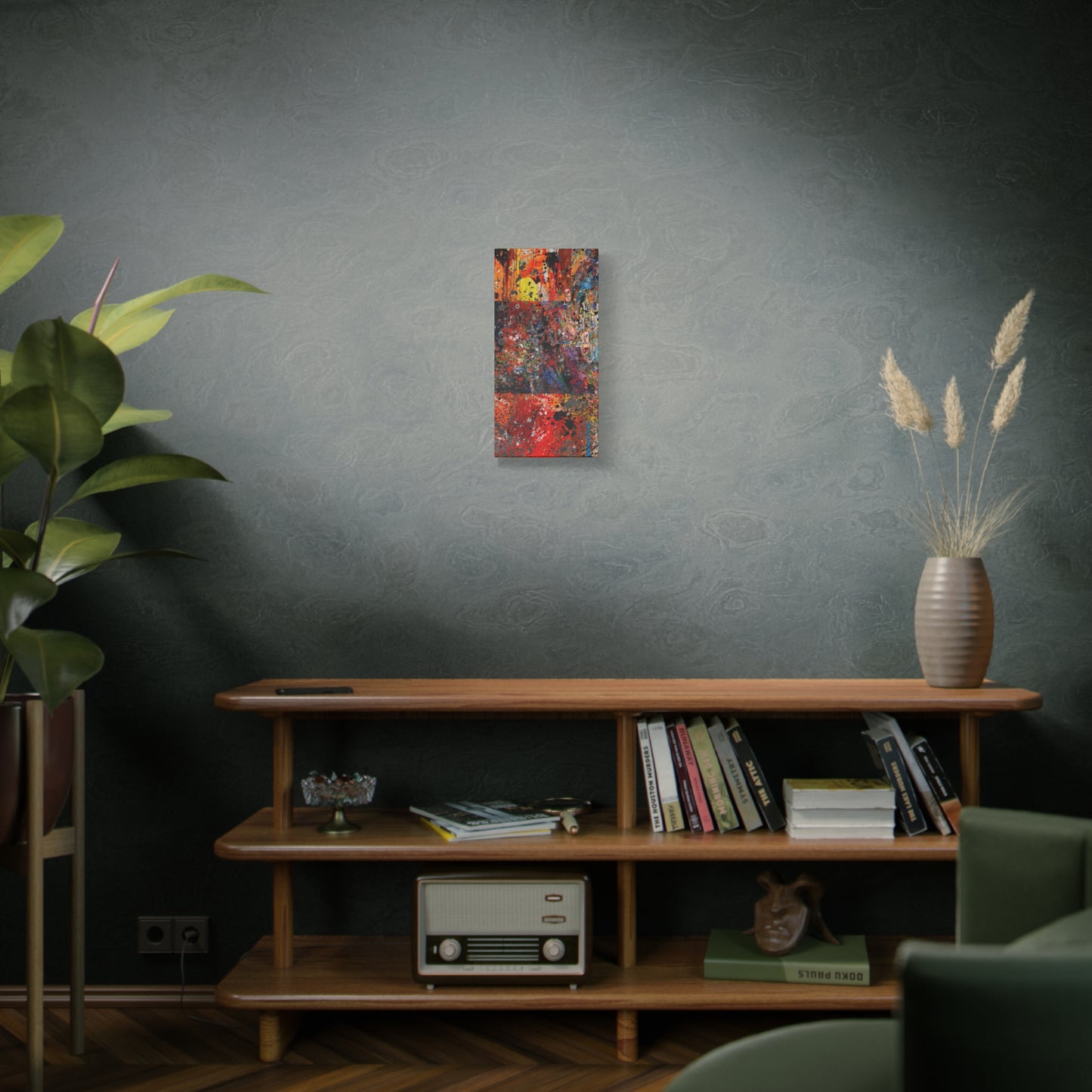 Red and orange abstract art canvas print hanging on wall above wooden shelf with books and plants