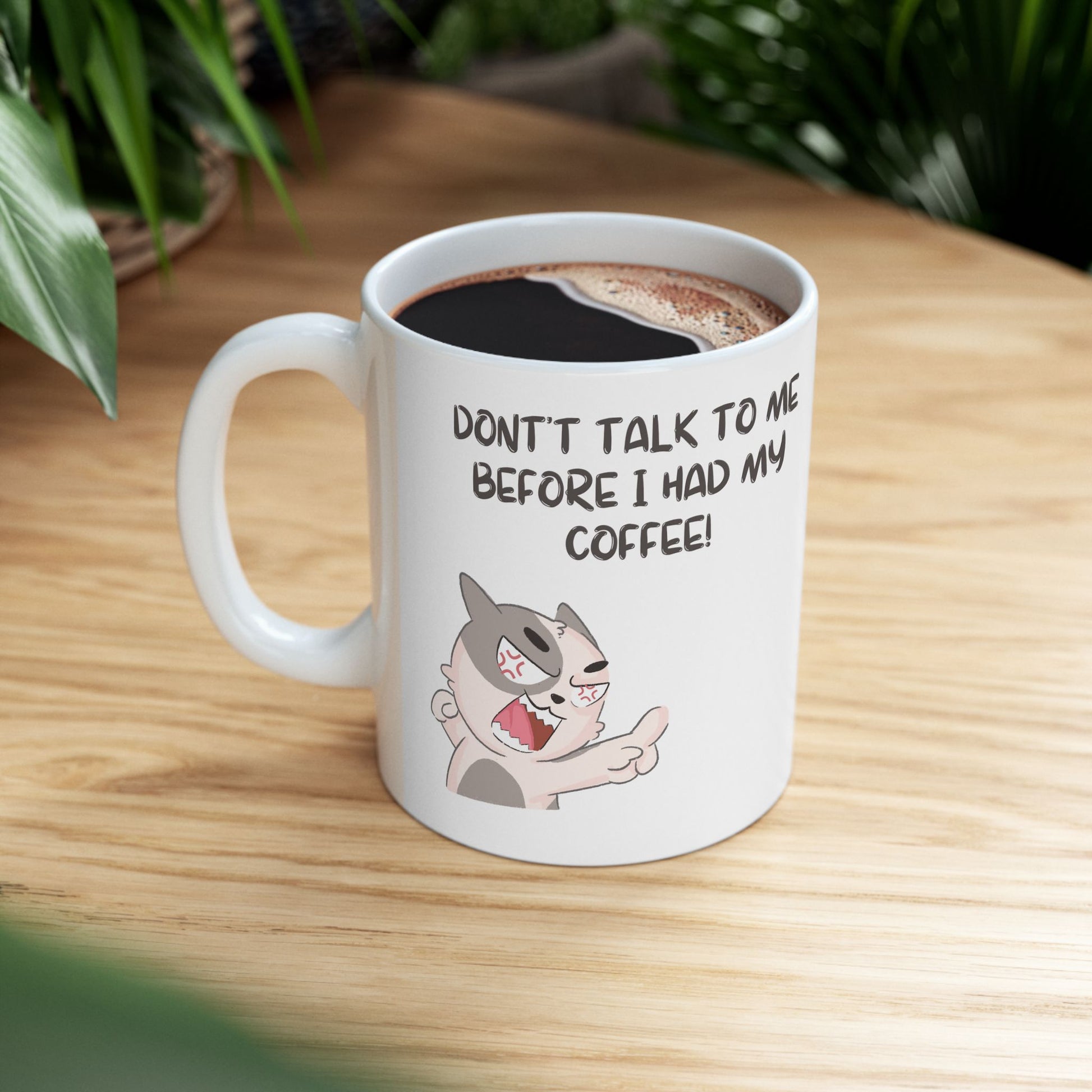 White don't talk to me mug with angry cat illustration and coffee inside on wooden table