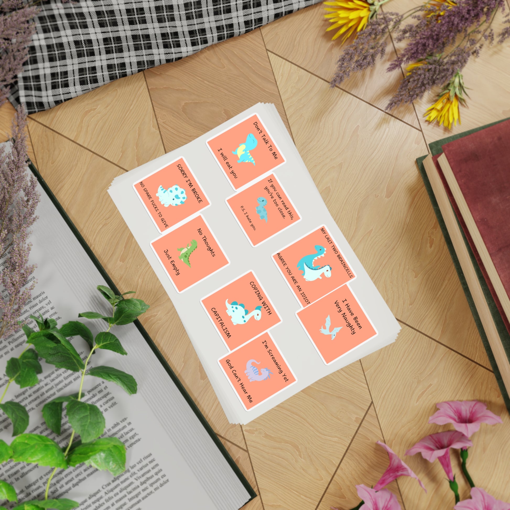 Funny edgy sarcastic cute dino sticker bundle featuring colorful dinosaur designs on a flat lay background