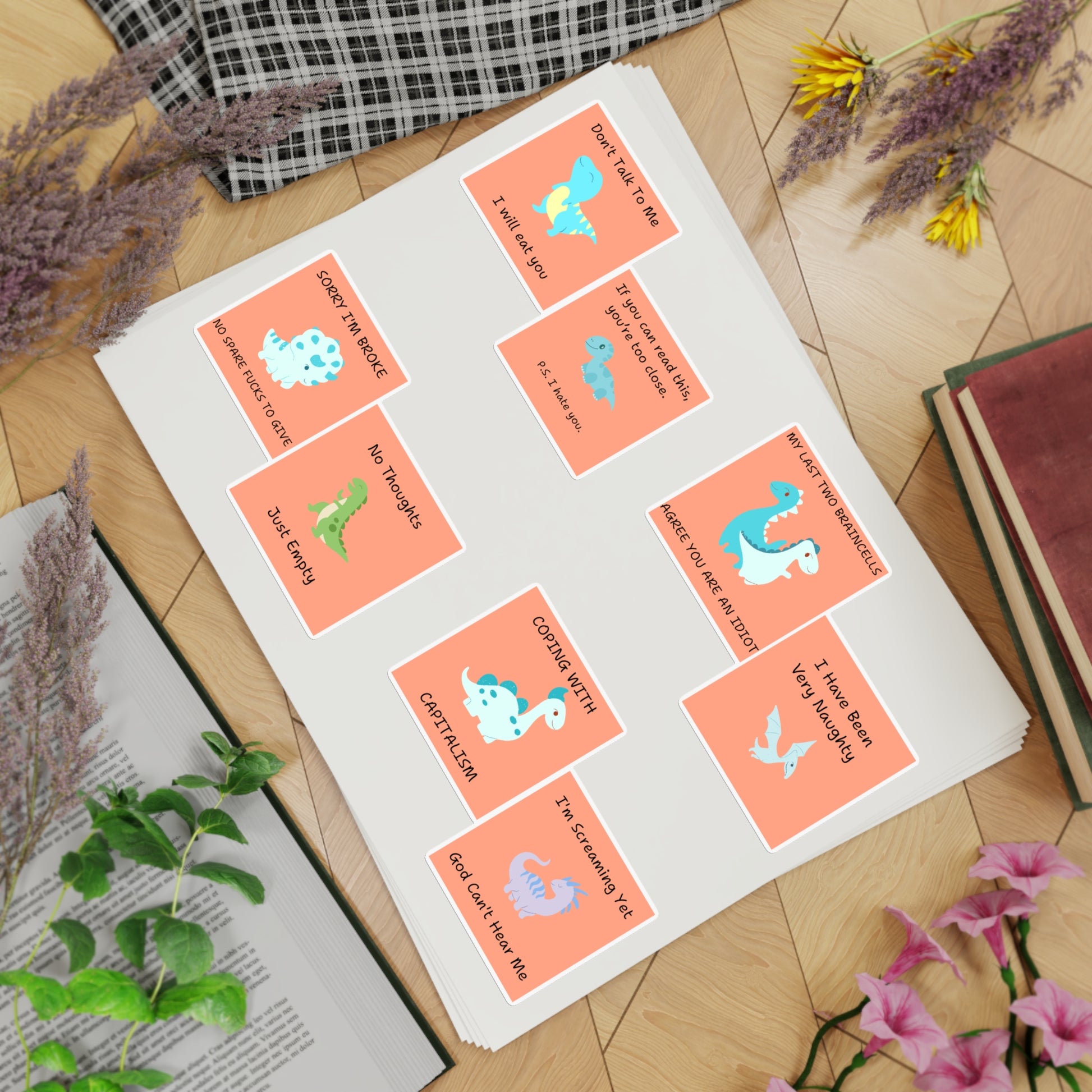 Funny edgy sarcastic cute dino sticker bundle with colorful designs and witty phrases displayed on a flat surface